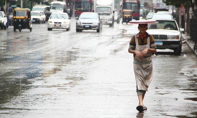 A child walking under the rain in Cairo - Ashraf Fawzy/Egypt Today