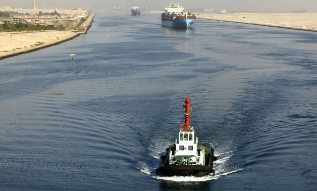 A tugboat and a tanker crossing the Suez Canal - File